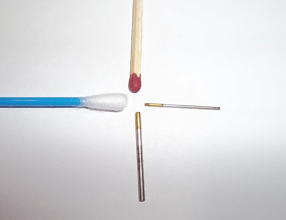 FUE punches used to harvest grafts for a DHI hair transplant, next to a match and a cotton bud